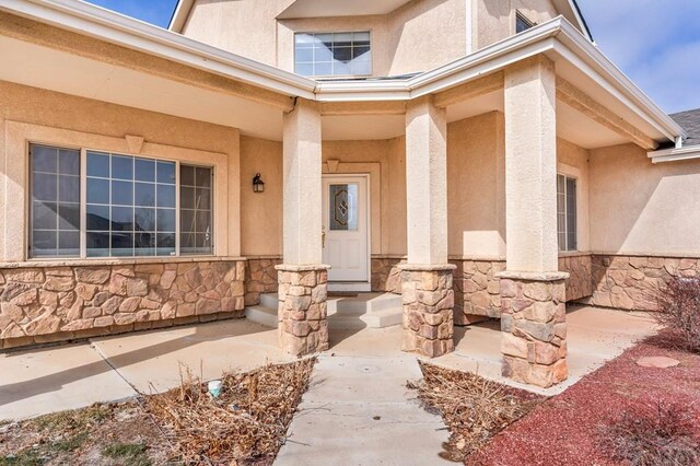 property entrance with stone siding and stucco siding