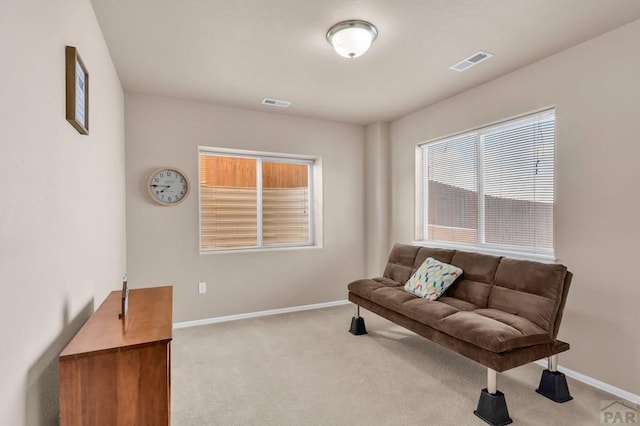 sitting room with carpet floors, visible vents, and baseboards