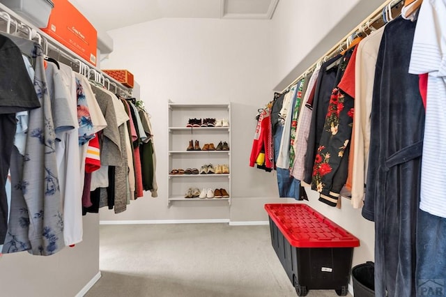 walk in closet with carpet floors and lofted ceiling