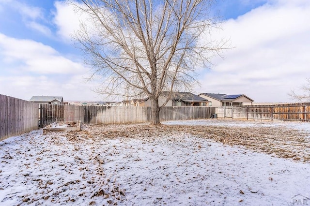 yard covered in snow with a fenced backyard