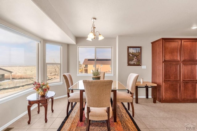 dining space featuring light tile patterned floors, baseboards, and a chandelier