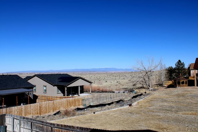 view of yard with fence and a mountain view