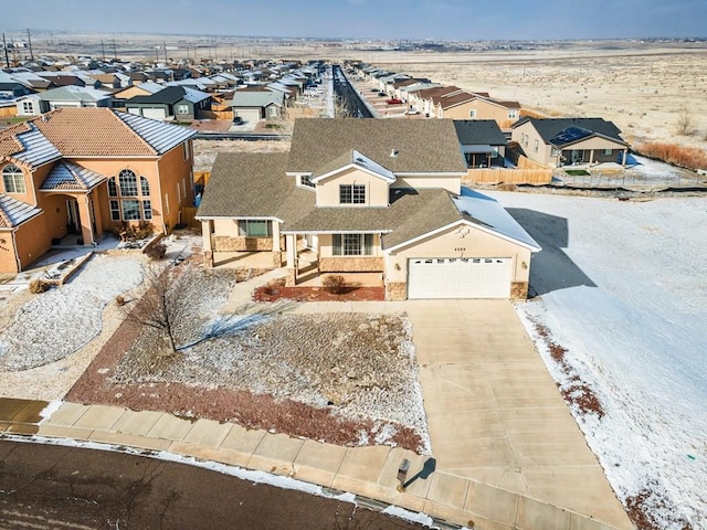 view of front of home with stucco siding, a garage, a residential view, stone siding, and driveway