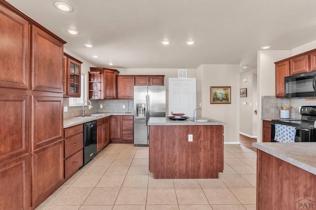 kitchen featuring light countertops, light tile patterned flooring, a sink, and black appliances