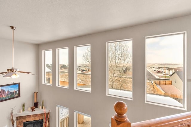 interior details with a fireplace, a textured ceiling, and ceiling fan