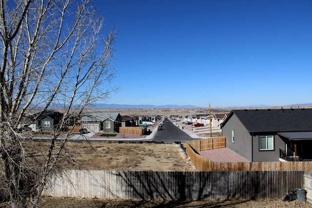 water view with fence private yard, a residential view, and a mountain view