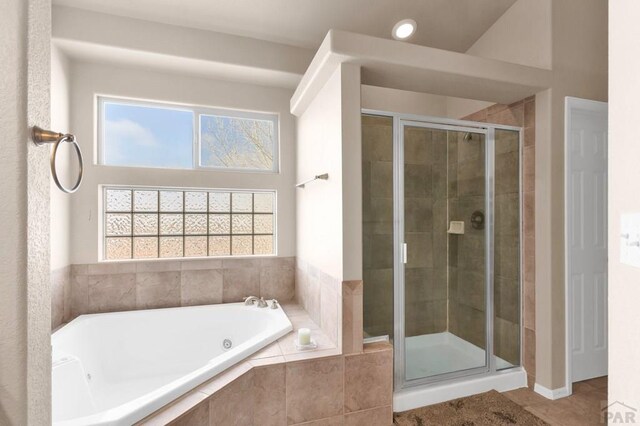 bathroom with a garden tub, a shower stall, and tile patterned floors