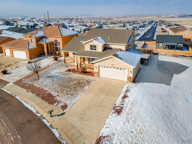 view of front of house with driveway, a garage, a residential view, fence, and stucco siding