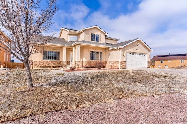 traditional home featuring stucco siding, concrete driveway, an attached garage, fence, and stone siding