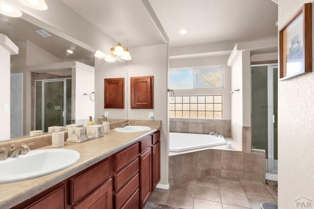 bathroom with a stall shower, a garden tub, a sink, and double vanity