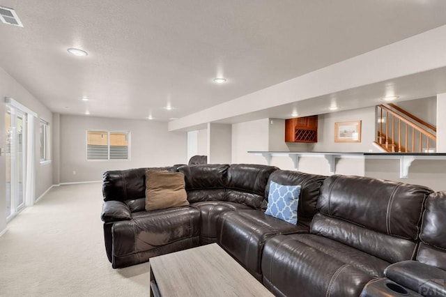 living area with light carpet, baseboards, visible vents, stairs, and recessed lighting