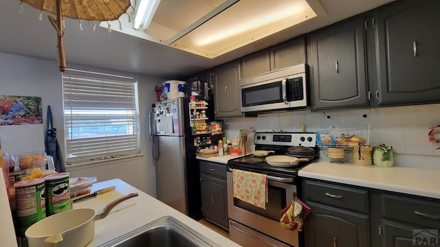 kitchen featuring appliances with stainless steel finishes, light countertops, and decorative backsplash