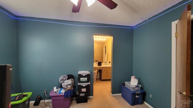 playroom featuring a ceiling fan, carpet floors, a textured ceiling, and baseboards