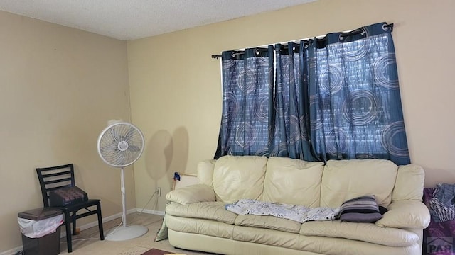 living room with a textured ceiling and baseboards