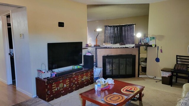 living room with baseboards and a tiled fireplace