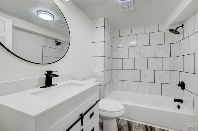 full bath with visible vents, toilet, vanity, wood finished floors, and  shower combination