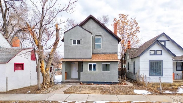 view of front of home featuring a chimney and stucco siding