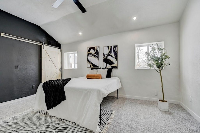 carpeted bedroom featuring lofted ceiling, ceiling fan, baseboards, and a barn door