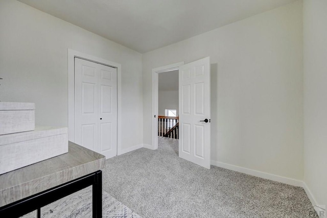 unfurnished office featuring light carpet and baseboards