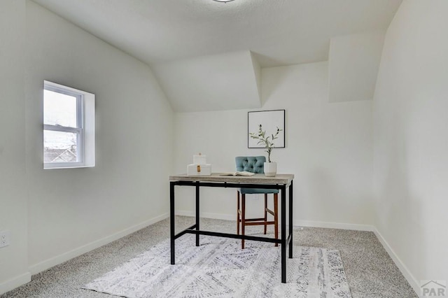 office featuring lofted ceiling, light carpet, and baseboards