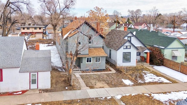 exterior space featuring roof with shingles, fence, a residential view, and stucco siding