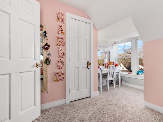 interior space featuring lofted ceiling and baseboards