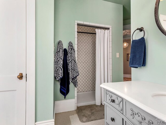 bathroom with a tile shower and vanity