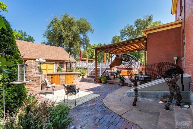 view of patio / terrace featuring exterior bar and fence