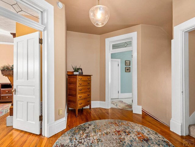 corridor featuring baseboards and wood finished floors