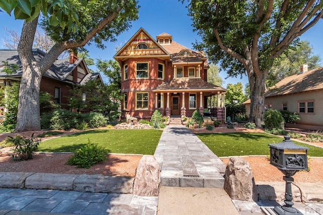 victorian home featuring covered porch and a front lawn