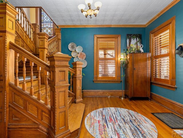 entryway with crown molding, baseboards, and wood finished floors