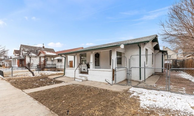 view of front of home with fence, a gate, and stucco siding