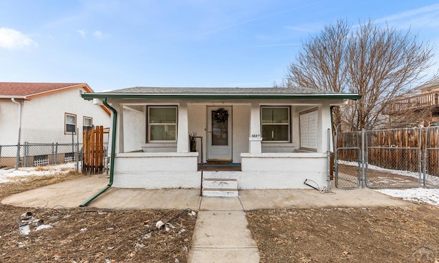 bungalow featuring a fenced front yard, a gate, a porch, and stucco siding