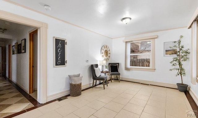 sitting room featuring ornamental molding, light tile patterned flooring, visible vents, and baseboards