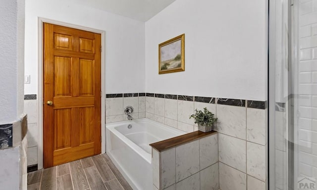 full bathroom featuring wood finish floors and a garden tub