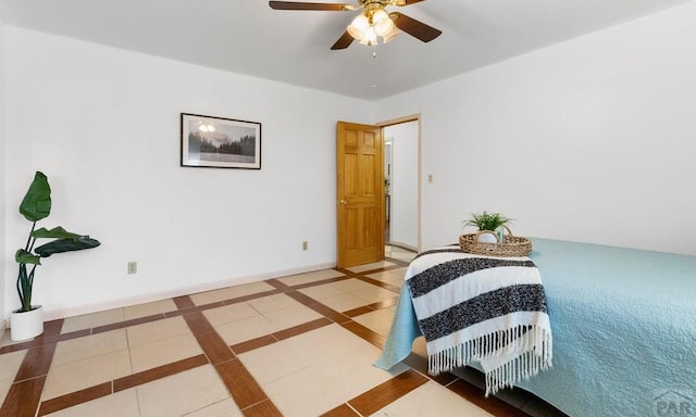 tiled bedroom with a ceiling fan and baseboards