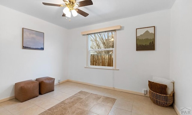 sitting room with light tile patterned floors, baseboards, and a ceiling fan