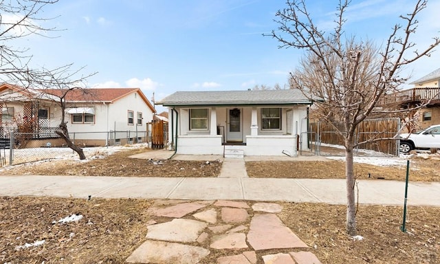 bungalow-style home with a porch and a fenced front yard