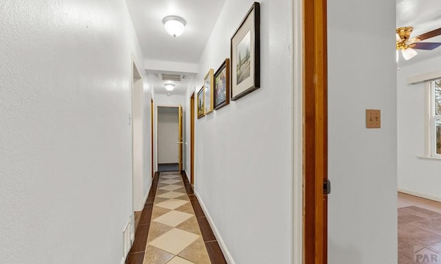 corridor featuring baseboards and visible vents