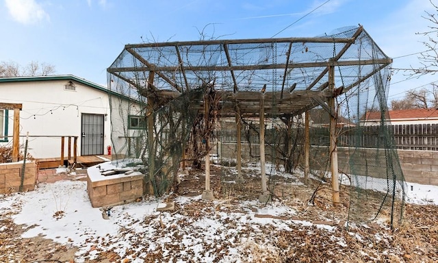 snow covered rear of property with fence