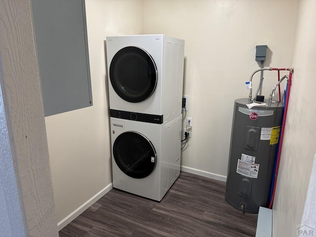 washroom featuring electric water heater, laundry area, dark wood-style flooring, baseboards, and stacked washer / drying machine