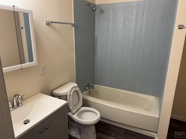 bathroom with toilet, shower / washtub combination, wood finished floors, and vanity