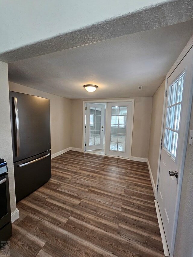 entryway featuring dark wood-style flooring, a textured ceiling, and baseboards