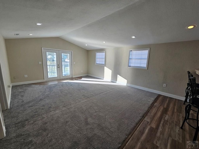 interior space with baseboards, lofted ceiling, dark wood-style floors, a textured ceiling, and french doors