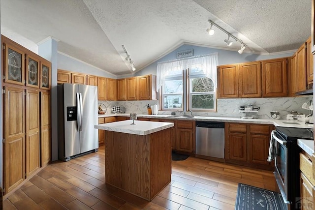 kitchen with brown cabinets, a kitchen island, stainless steel appliances, and light countertops