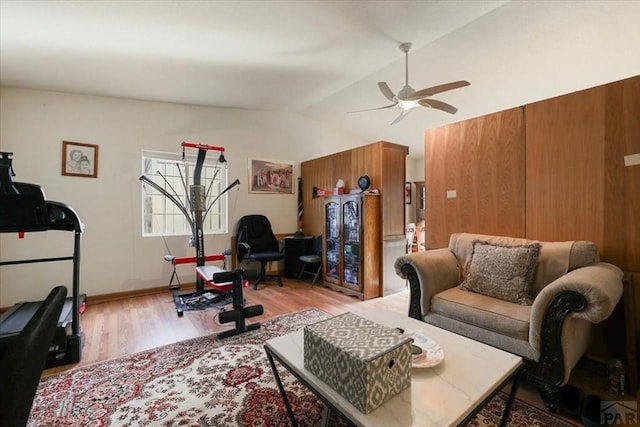 living room with a ceiling fan, lofted ceiling, and light wood finished floors