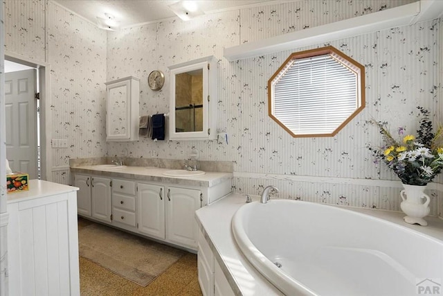 bathroom featuring double vanity, wallpapered walls, a garden tub, and a sink