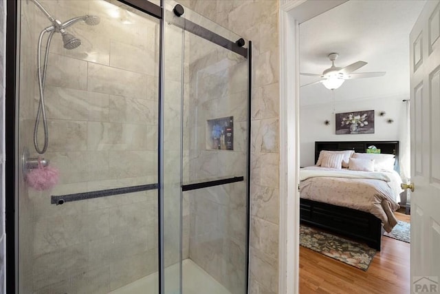 bathroom featuring a shower stall, a ceiling fan, wood finished floors, and ensuite bathroom