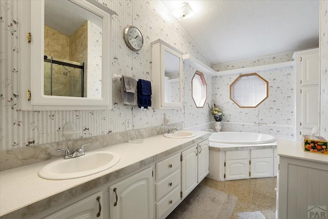 bathroom with a sink, wallpapered walls, a bath, and a stall shower