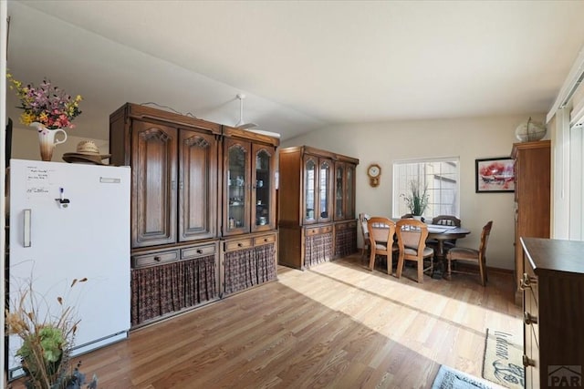 dining room featuring lofted ceiling and light wood-type flooring